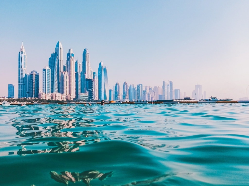 Mann schwimmt in Pool vor der Kulisse Dubais