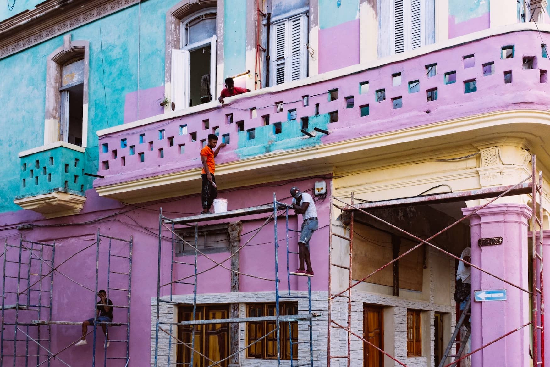 Bauarbeiter an einem bunten Haus in der Altstadt der kubanischen Hauptstadt Havanna