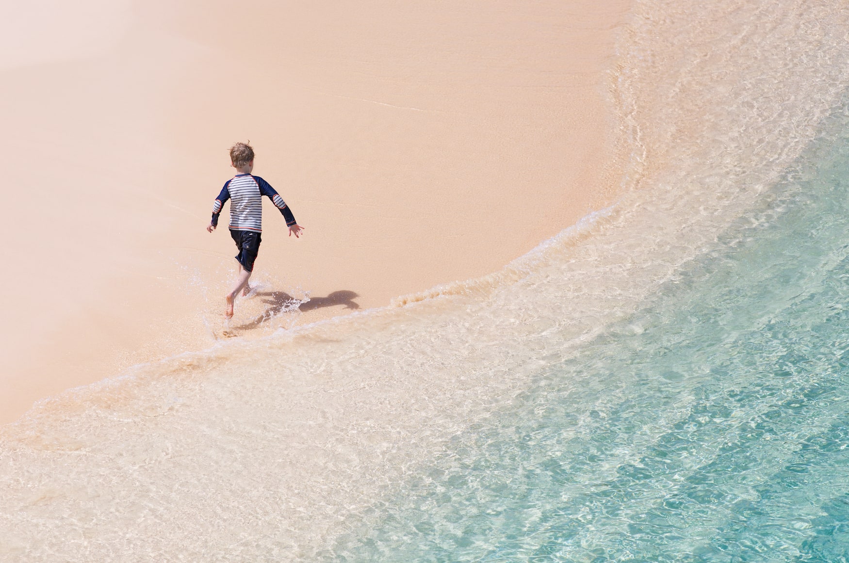 Kleiner Junge rennt ins Meer