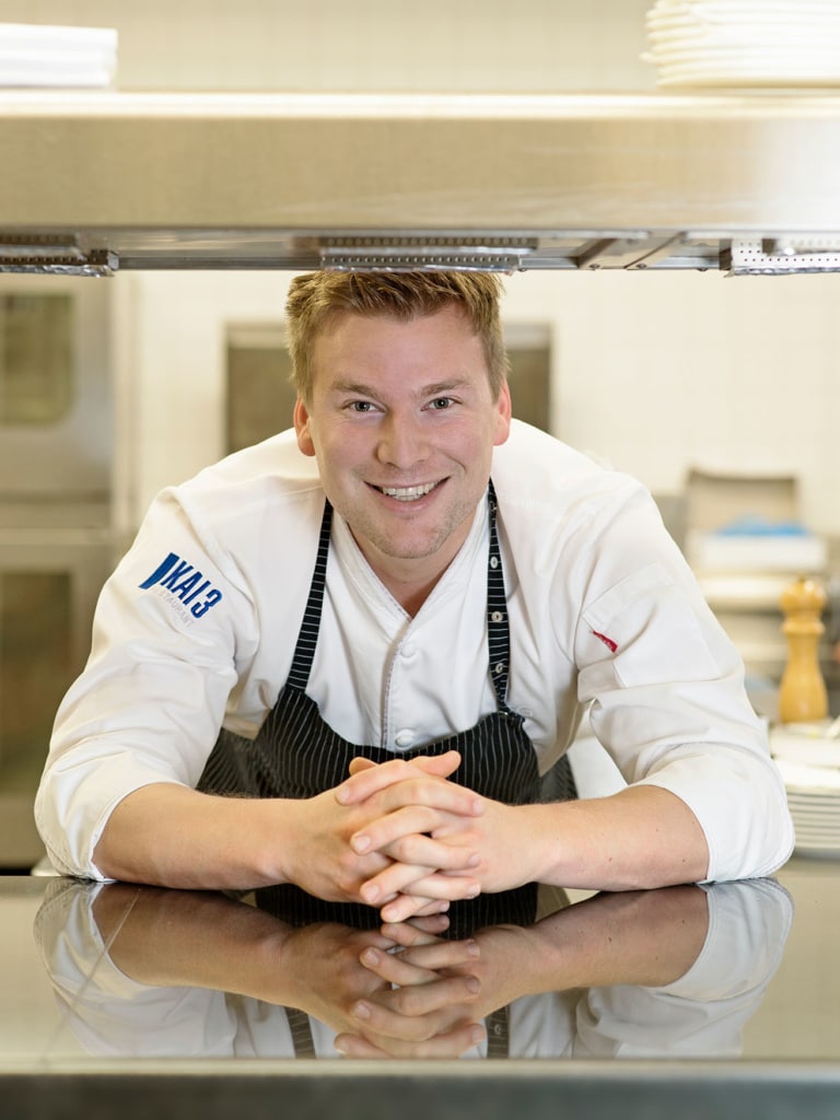 Felix Gabel guckt durch den Pass in seiner Küche
