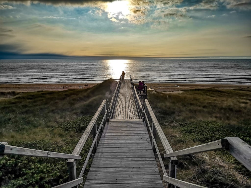 Ein langer Holzsteg führt über die Dünen runter zum Meer nach Sylt.