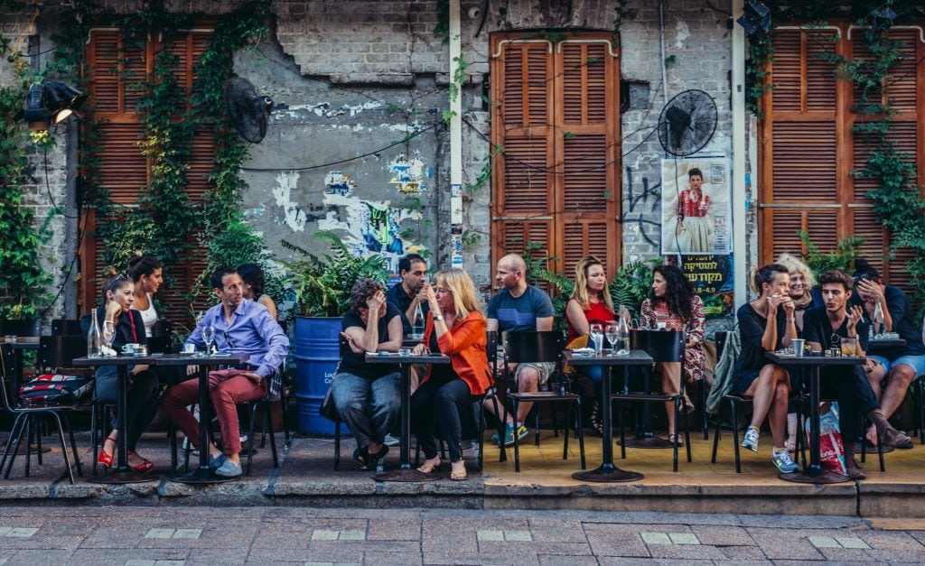 Gäste sitzen draußen vor einem Cafe auf dem Rothschild Boulevard in Tel Aviv