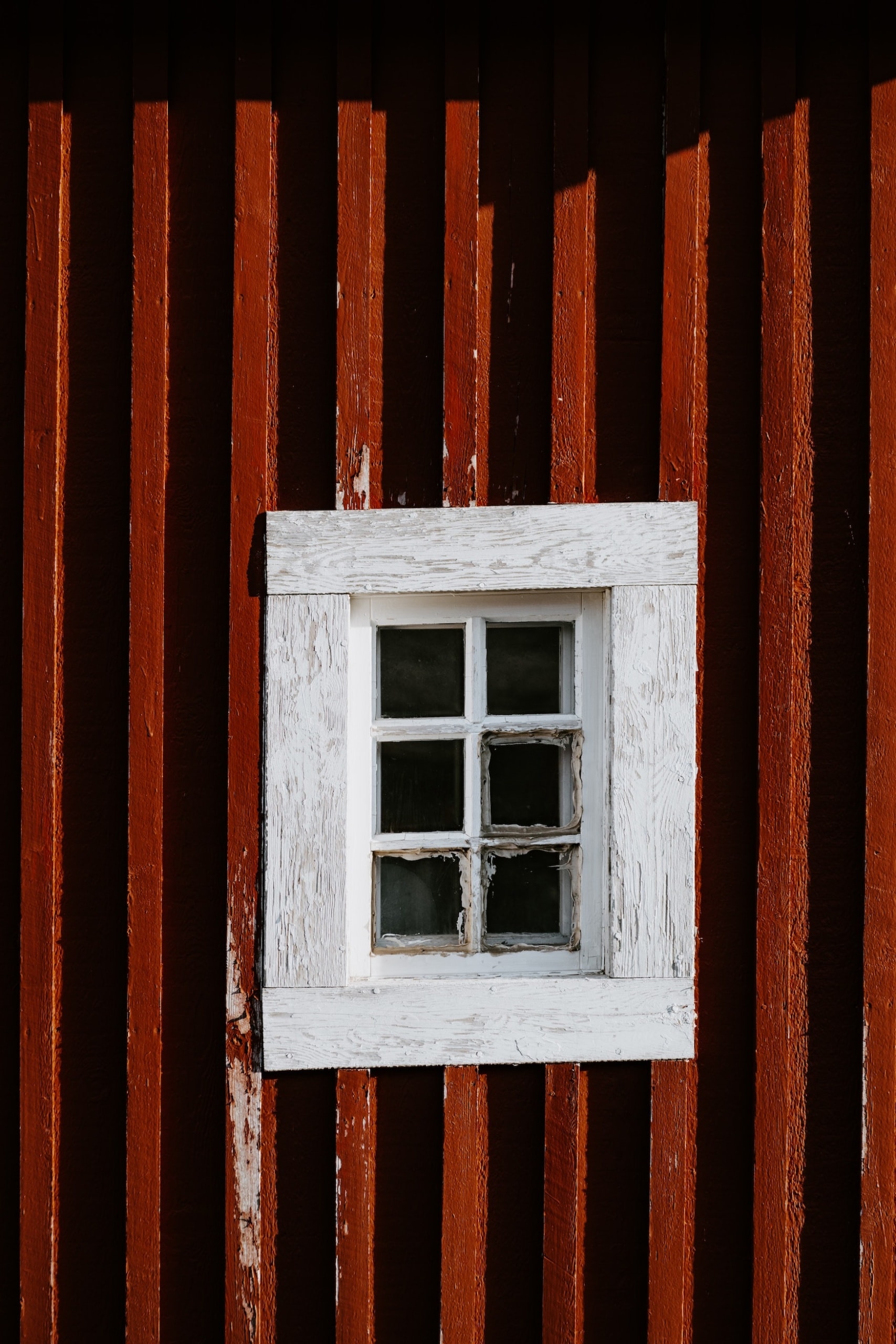 Weißes Fenster auf rotem Holzhaus