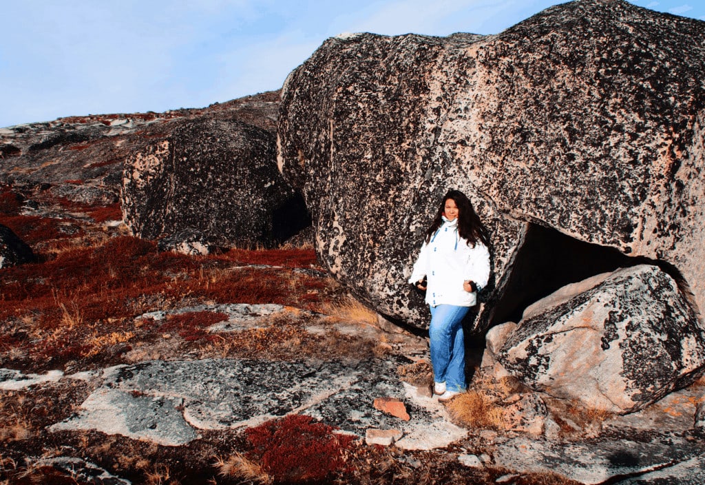 Rote Wanderroute Ilulissat. Frau lehnt an Felsen