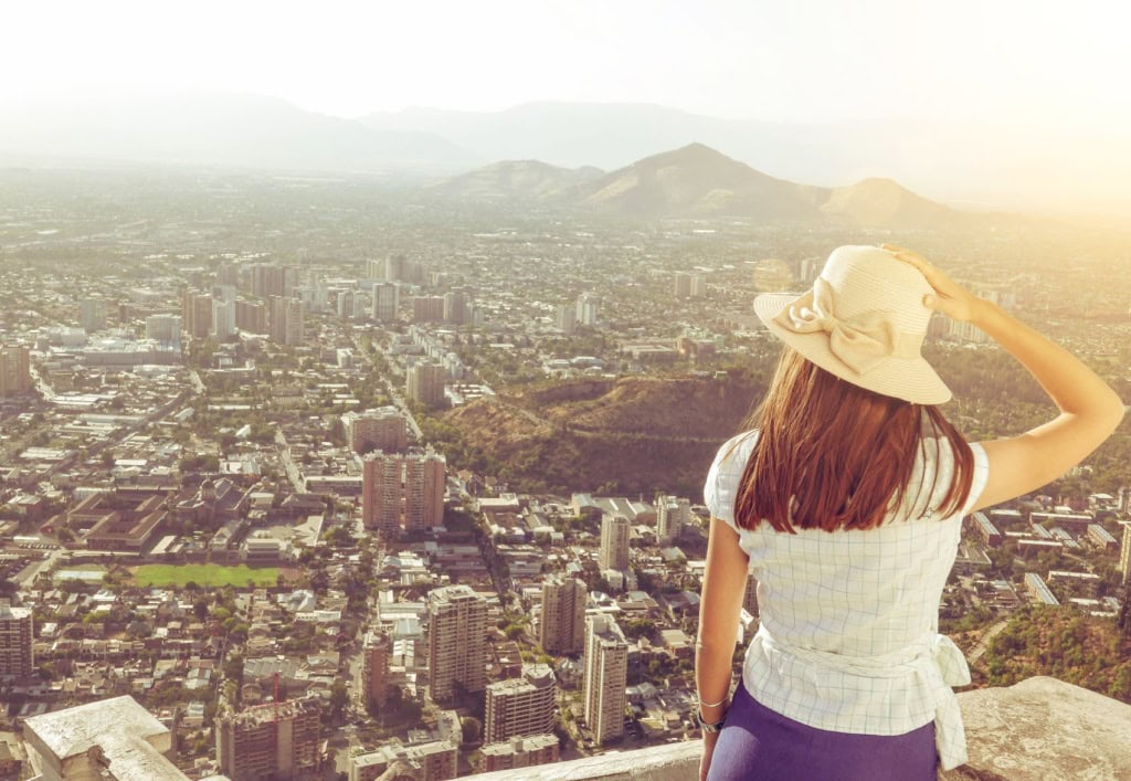 Frau mit Sonnenhut genießt Ausblick auf Panorama von Santiago de Chile