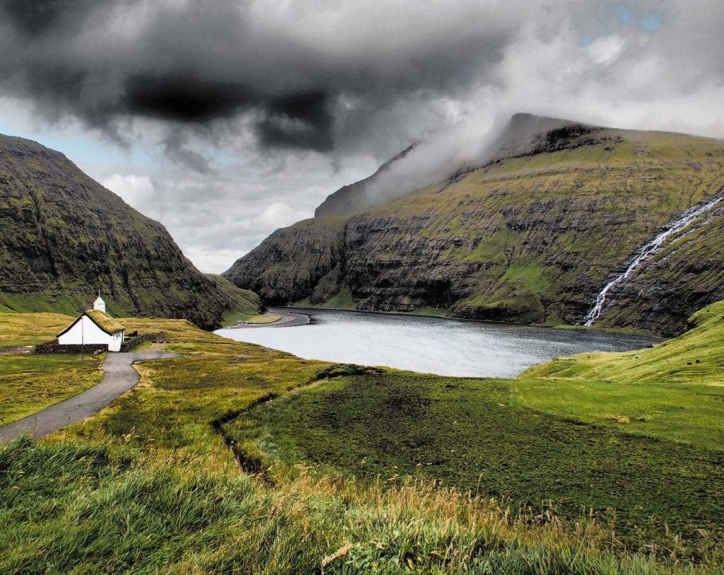 Bucht mit Wasserfall und Kirche auf den Färöern