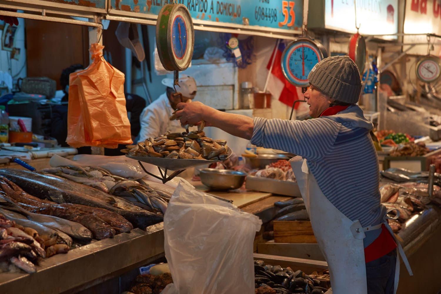 Chilenischer Mann wiegt Fisch in Markthalle
