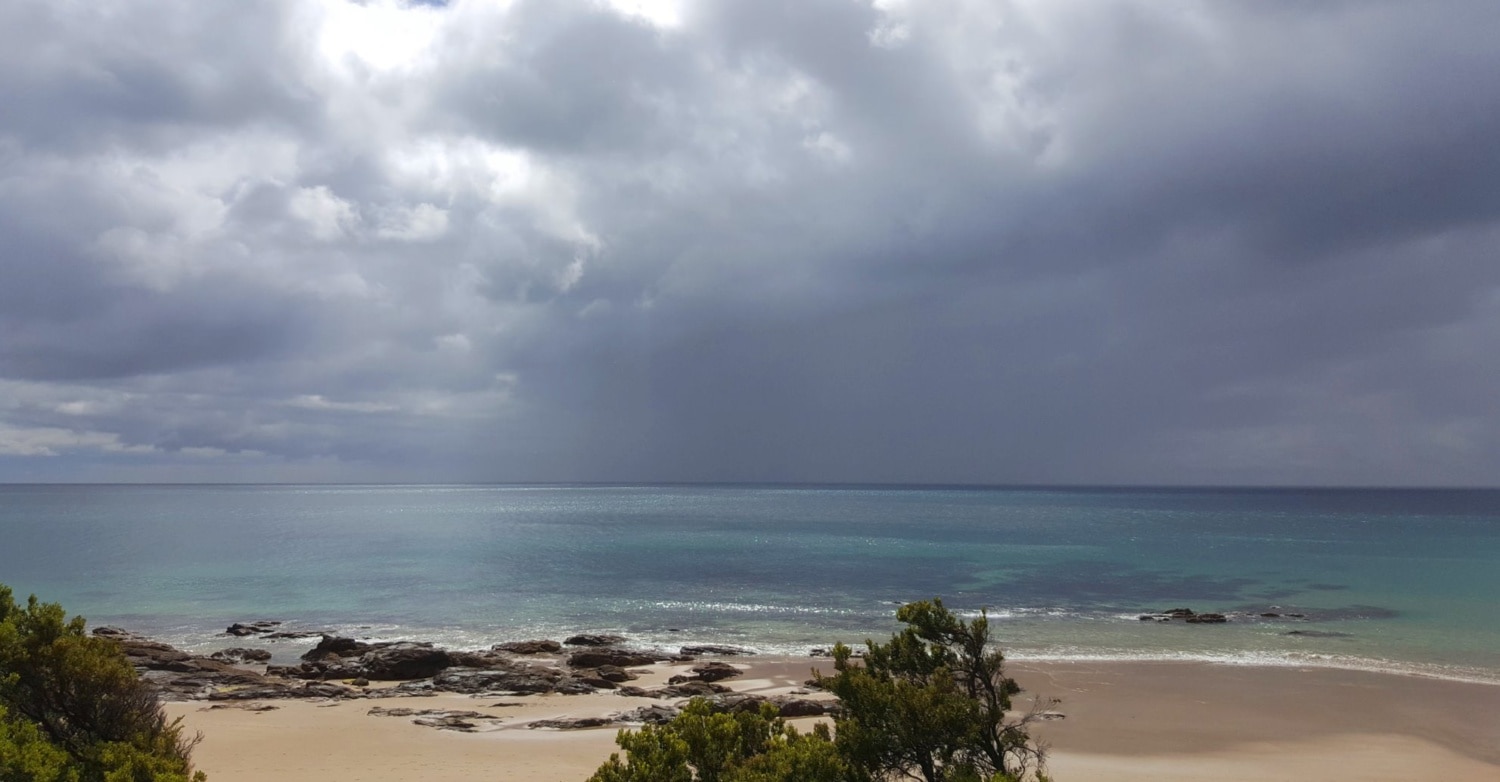 Wilder, tropischer Strand mit feinem Sand und Felsen