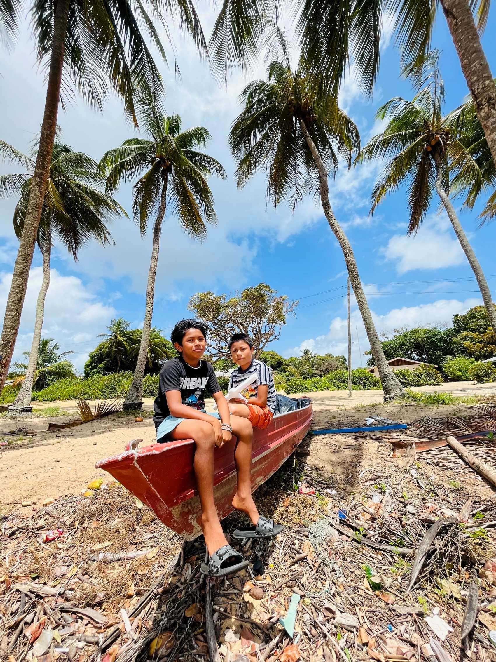 Indigene Jungen auf Boot an Land im Dorf Galibi, Suriname