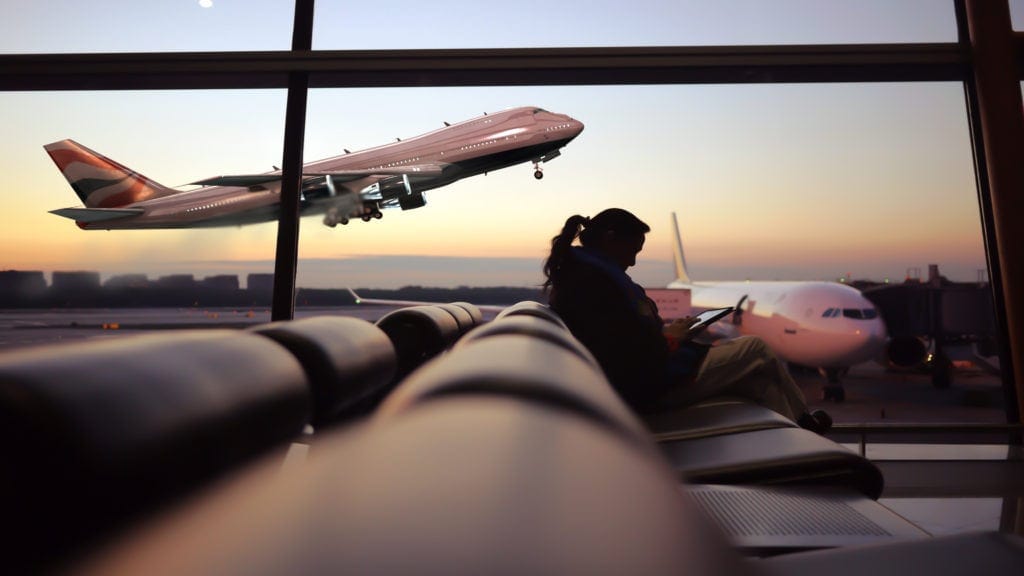 Zwischenstopp: Frau am Flughafen am Gate wartend