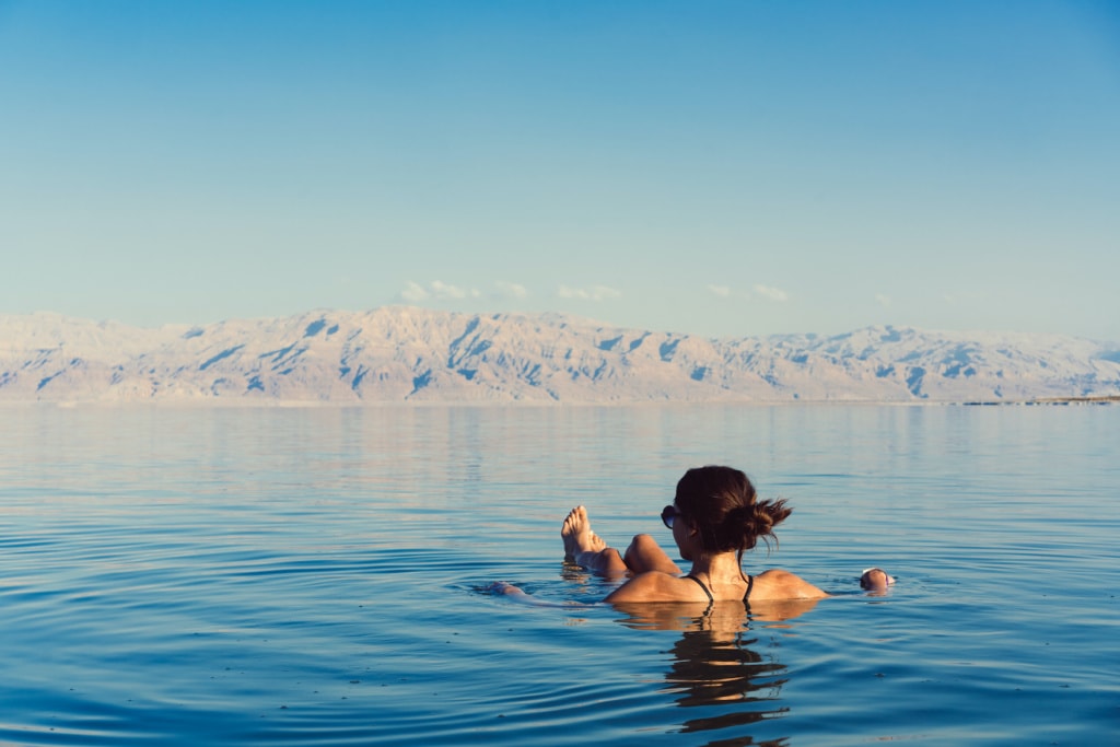 Frau schwimmt auf Wasseroberfläche auf dem Toten Meer in Jordanien