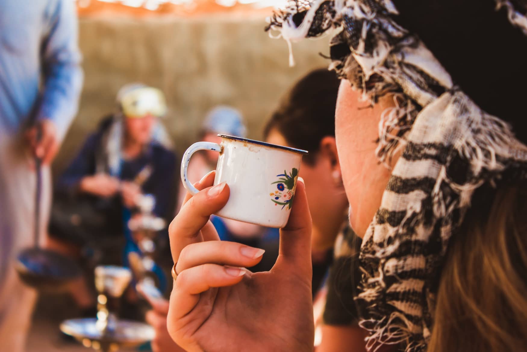 Touristin trinkt Ingwer-Tee aus einer Emaille-Tasse im Wadi el Gemal Nationalpark