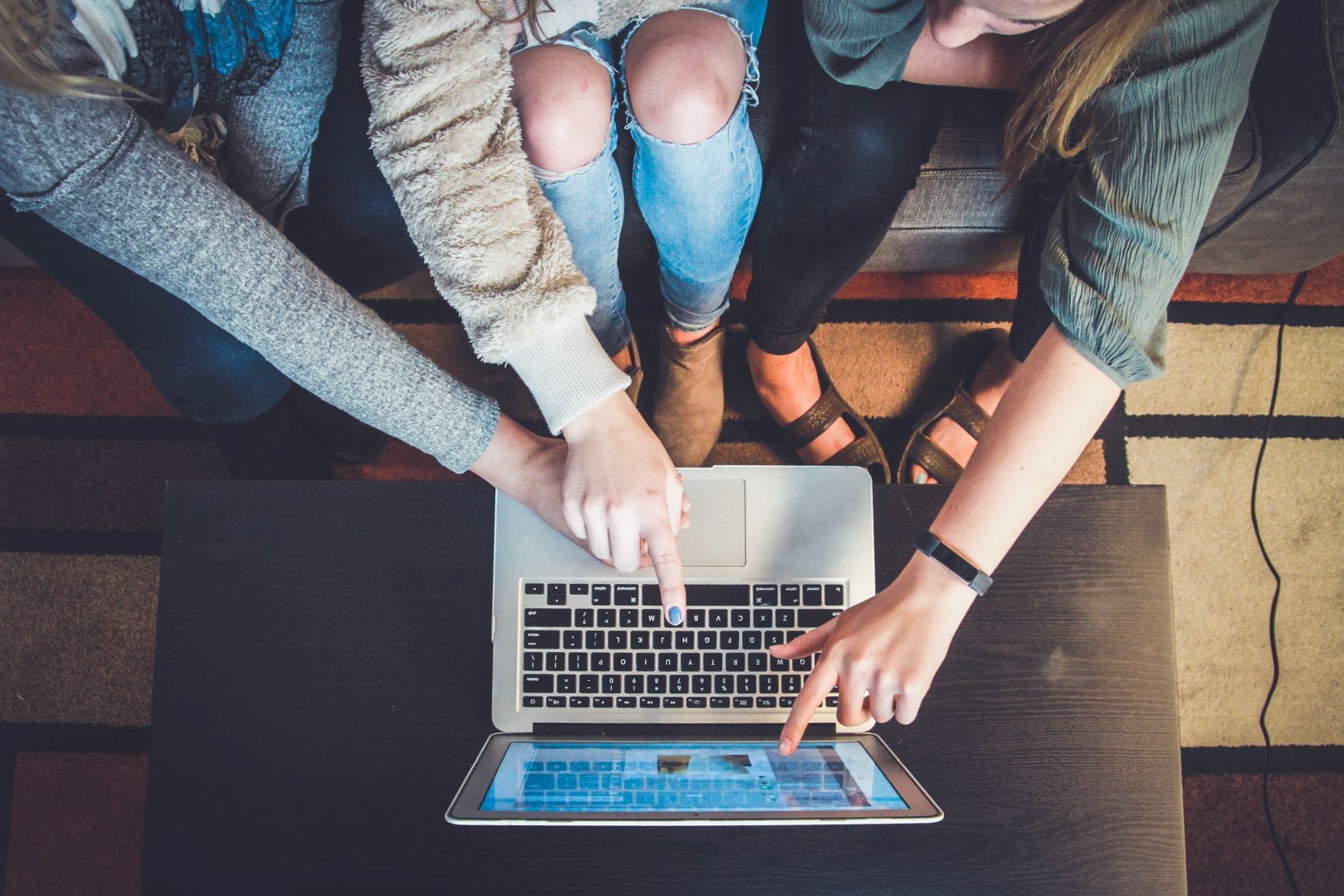 Drei junge Frauen sitzen vor einem Notebook