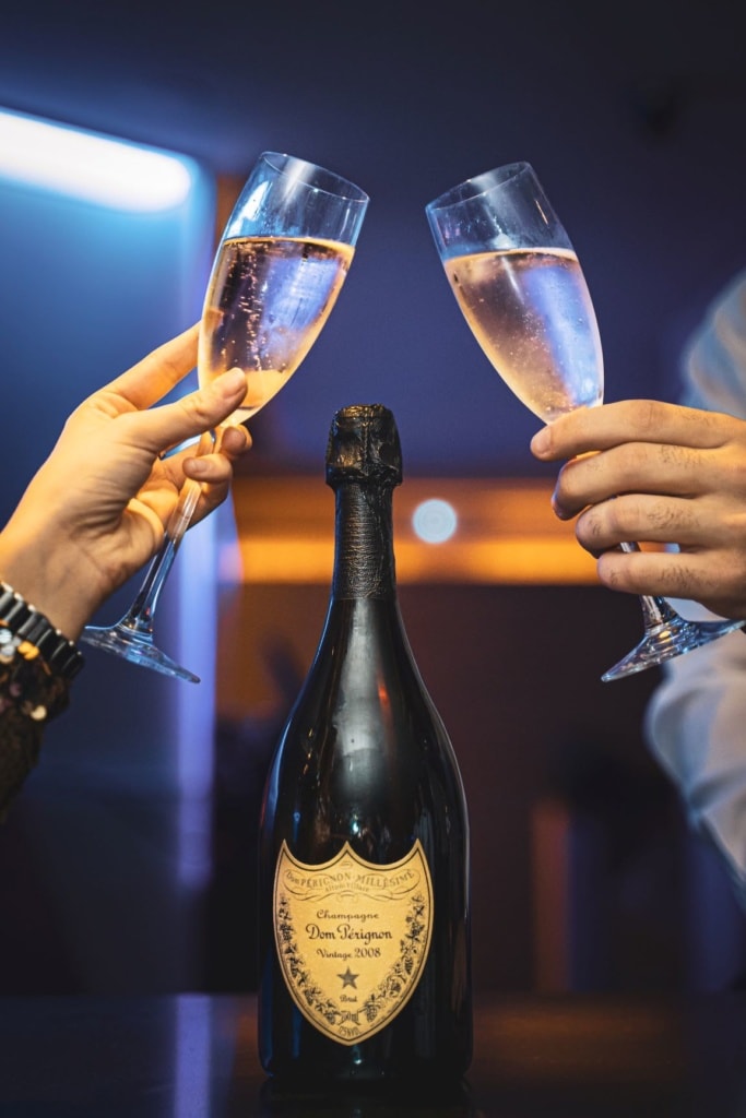 Mann und Frau stoßen mit Champagner-Gläsern an