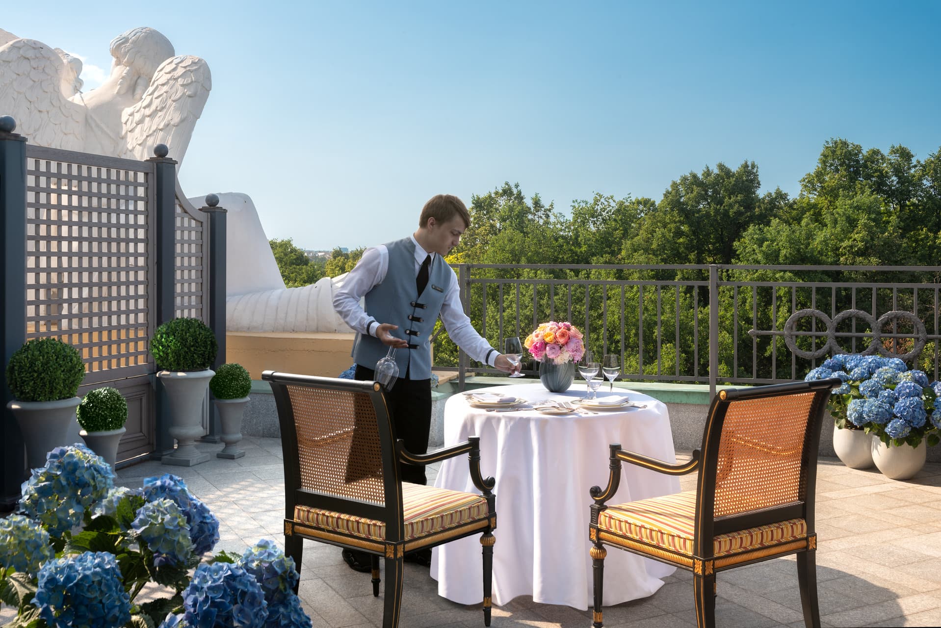Mann serviert Frühstück auf einer Hotelterrasse