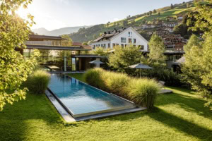 das Hotel Wiesergut mit Pool in der Kulisse der Berge