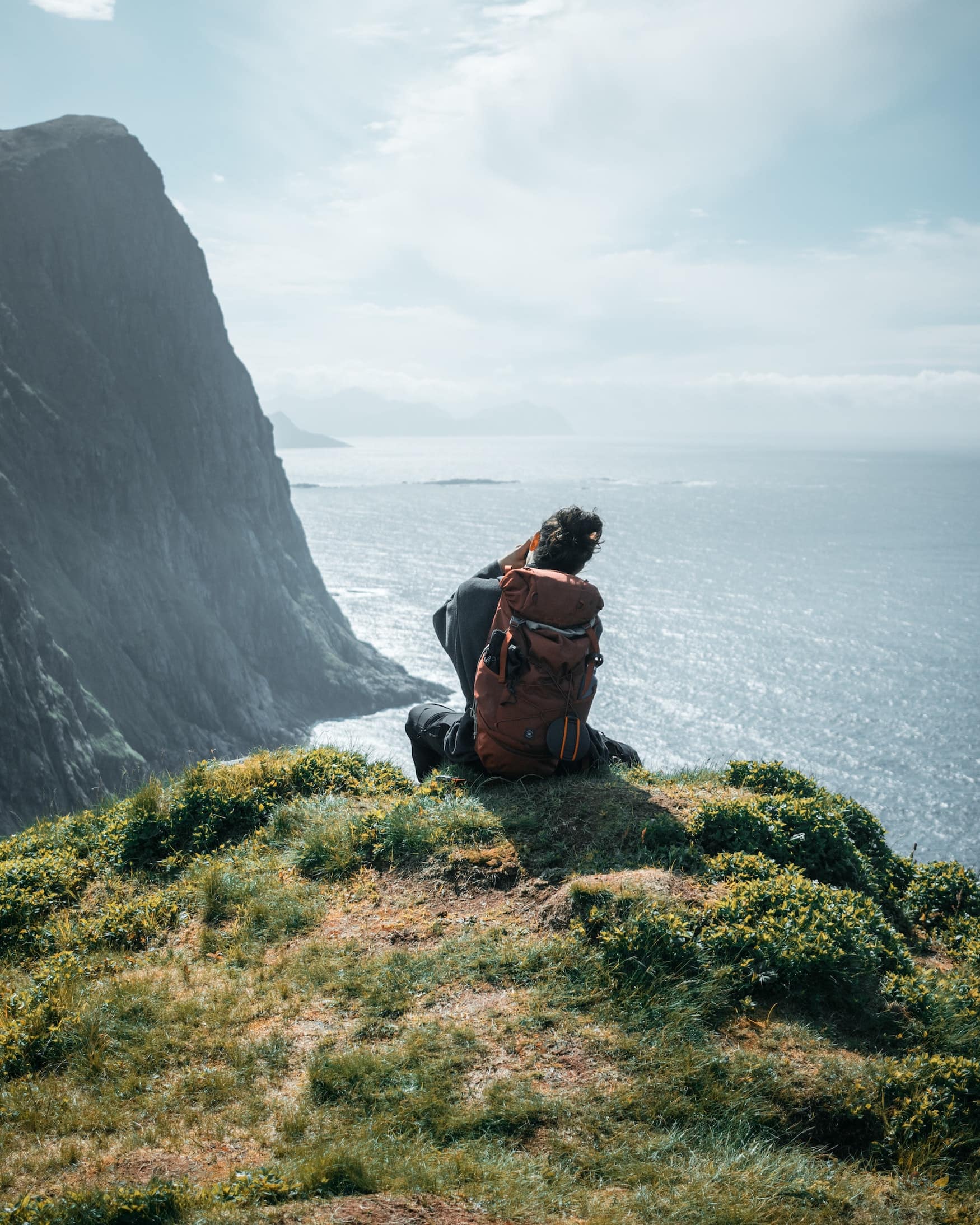 Mann sitzt am Strand auf den Lofoten in Norwegen