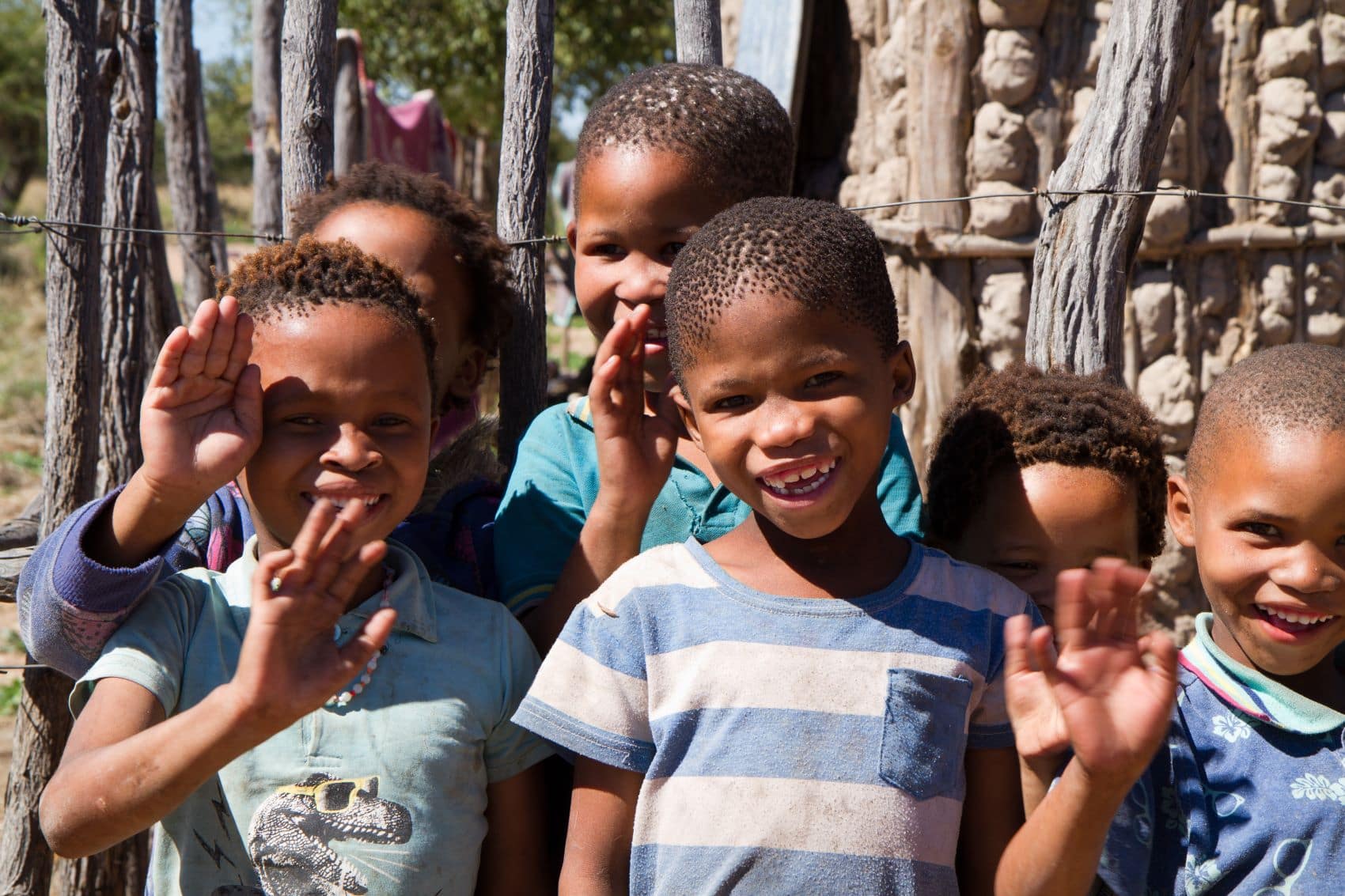 Kinder in Namibia winken lachend in die Kamera