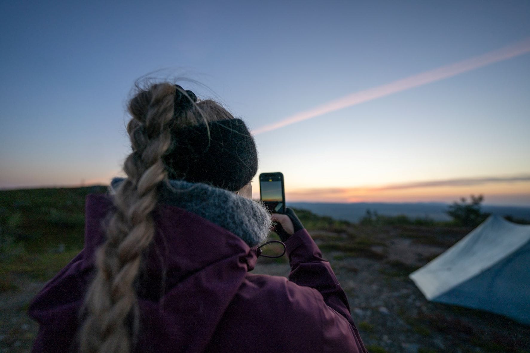 Frau macht Foto von Zelt und Meer in Finnland