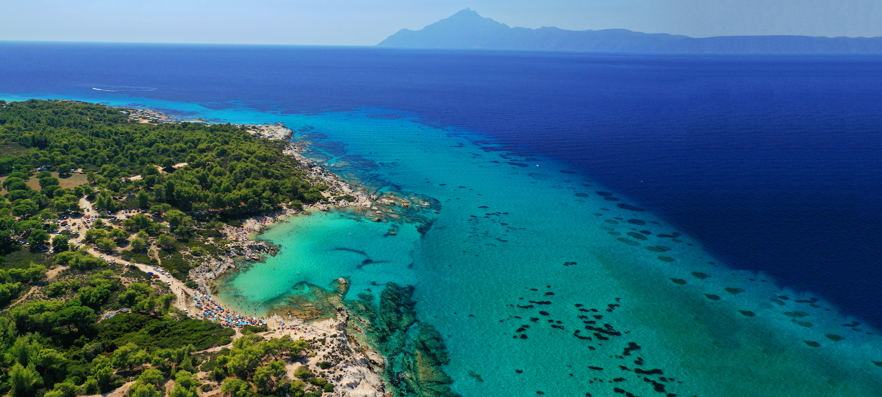 Die wunderschöne türkisfarbene Bucht und der Strand von Kavourotripes mit felsiger Meereslandschaft auf der Halbinsel Sithonia, Chalkidiki