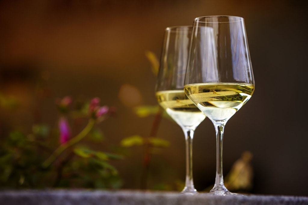 zwei Gläser Riesling auf einem Tischbeim weinwandernauf der Rieslingroute