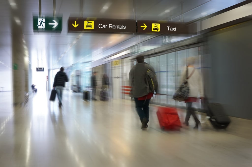 Flughafen-Passagiere auf dem Weg zur Mietwagen-Station