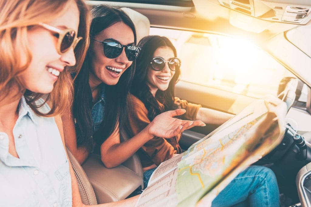 Drei junge Frauen in einem Mietwagen unterwegs