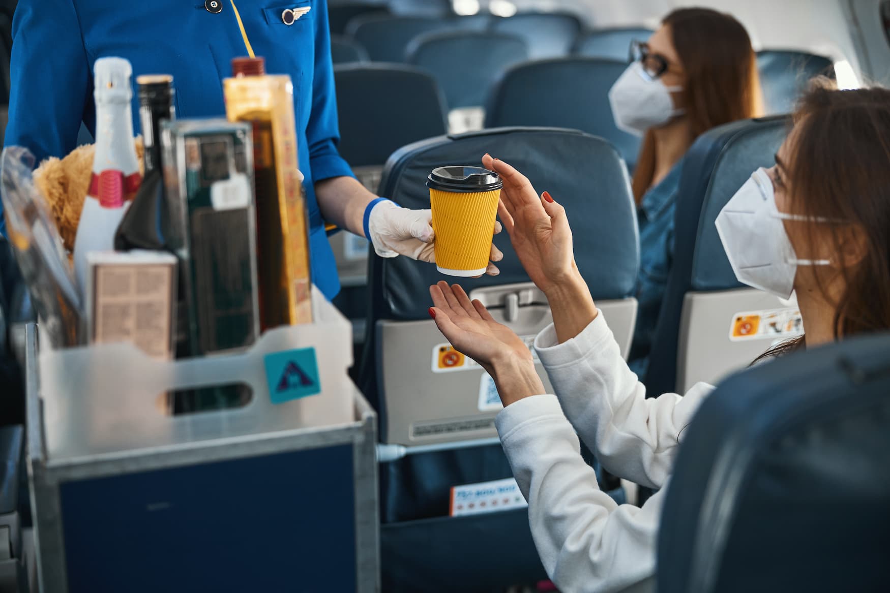 Frau mit Becher im Flugzeug