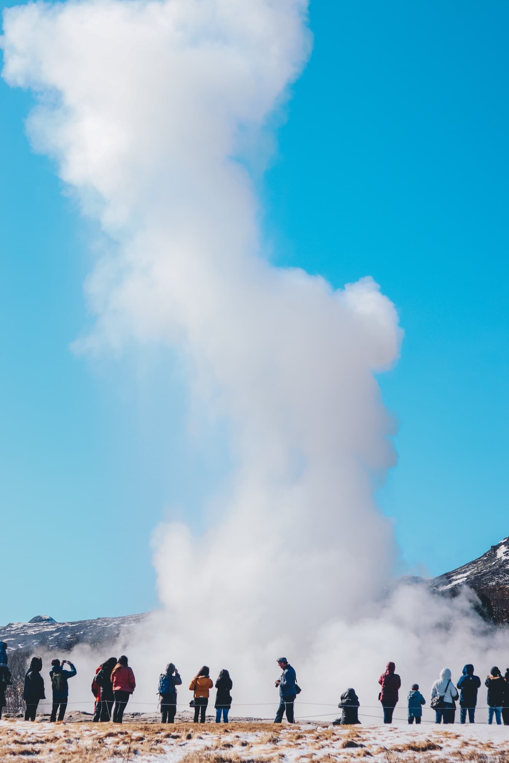 Menschen bestaunen ausbrechenden Geysir in Island