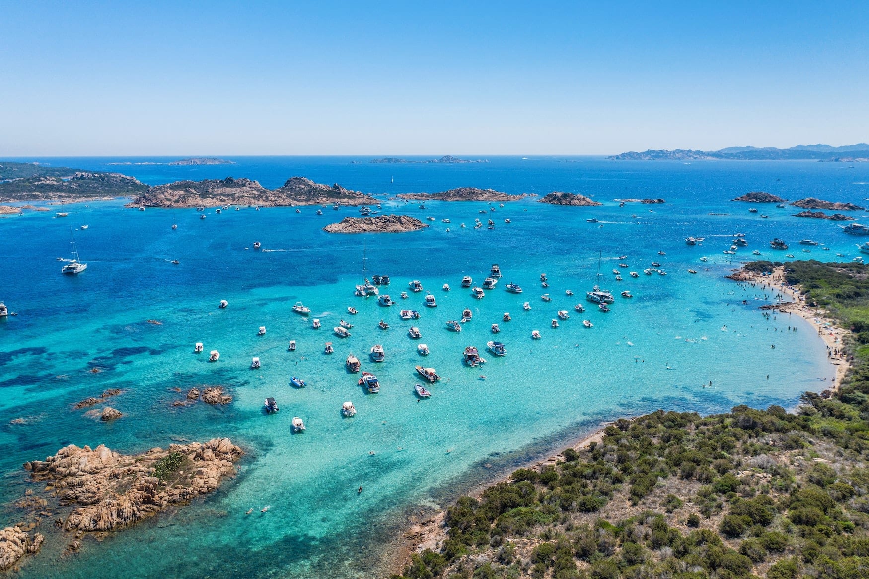 Boote liegen in Bucht auf Sardinien. Das türkisfarbene Wasser ist sicherlich eine der größten Sehenswürdigkeiten der Mittelmeerinsel