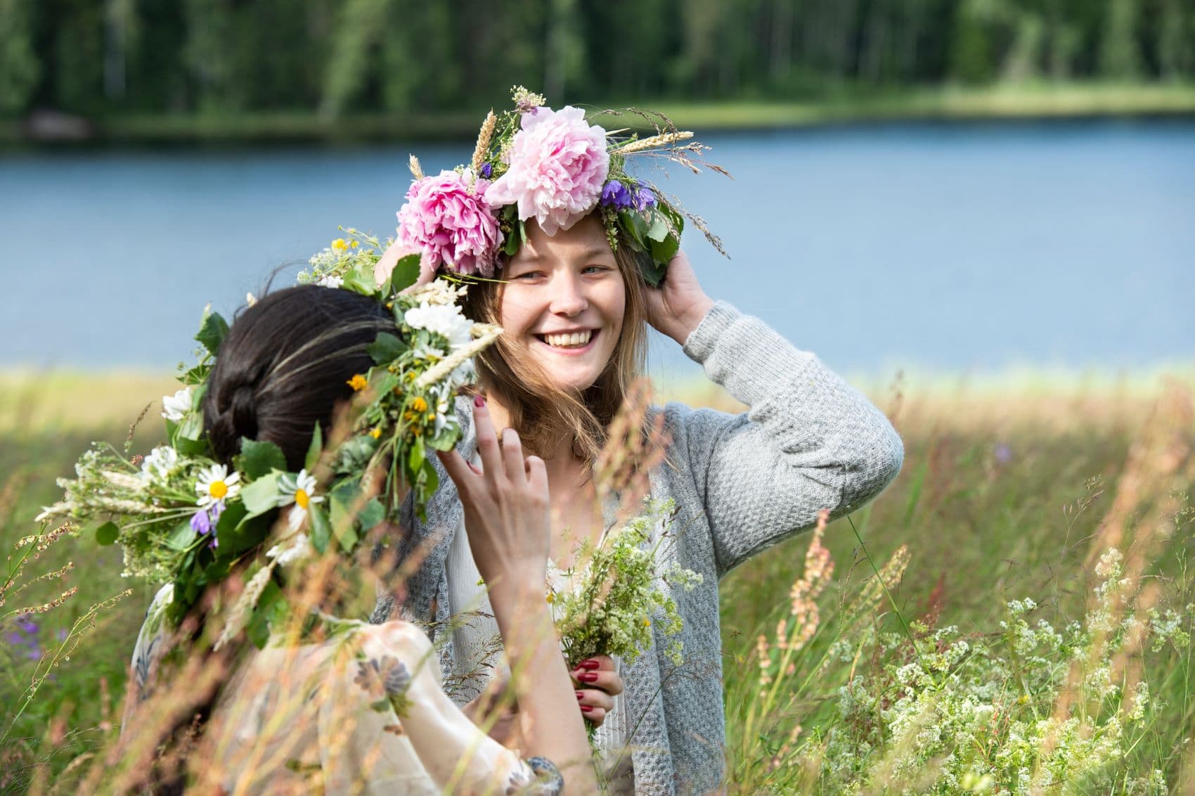 Frauen stecken Blumen-Kranz auf Kopf 