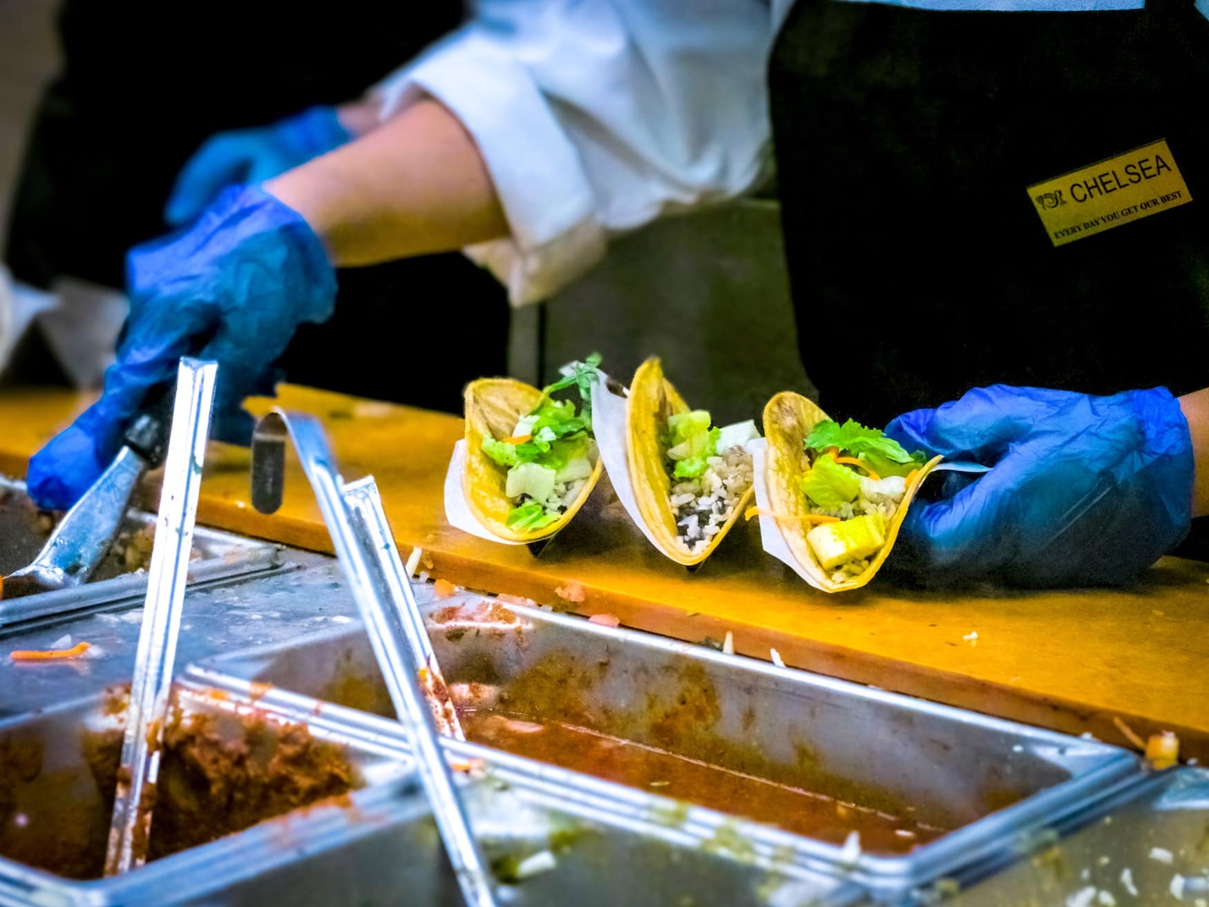Mann verteilt Guacamole in Tacos auf einem Streed-Food-Markt in Mexiko