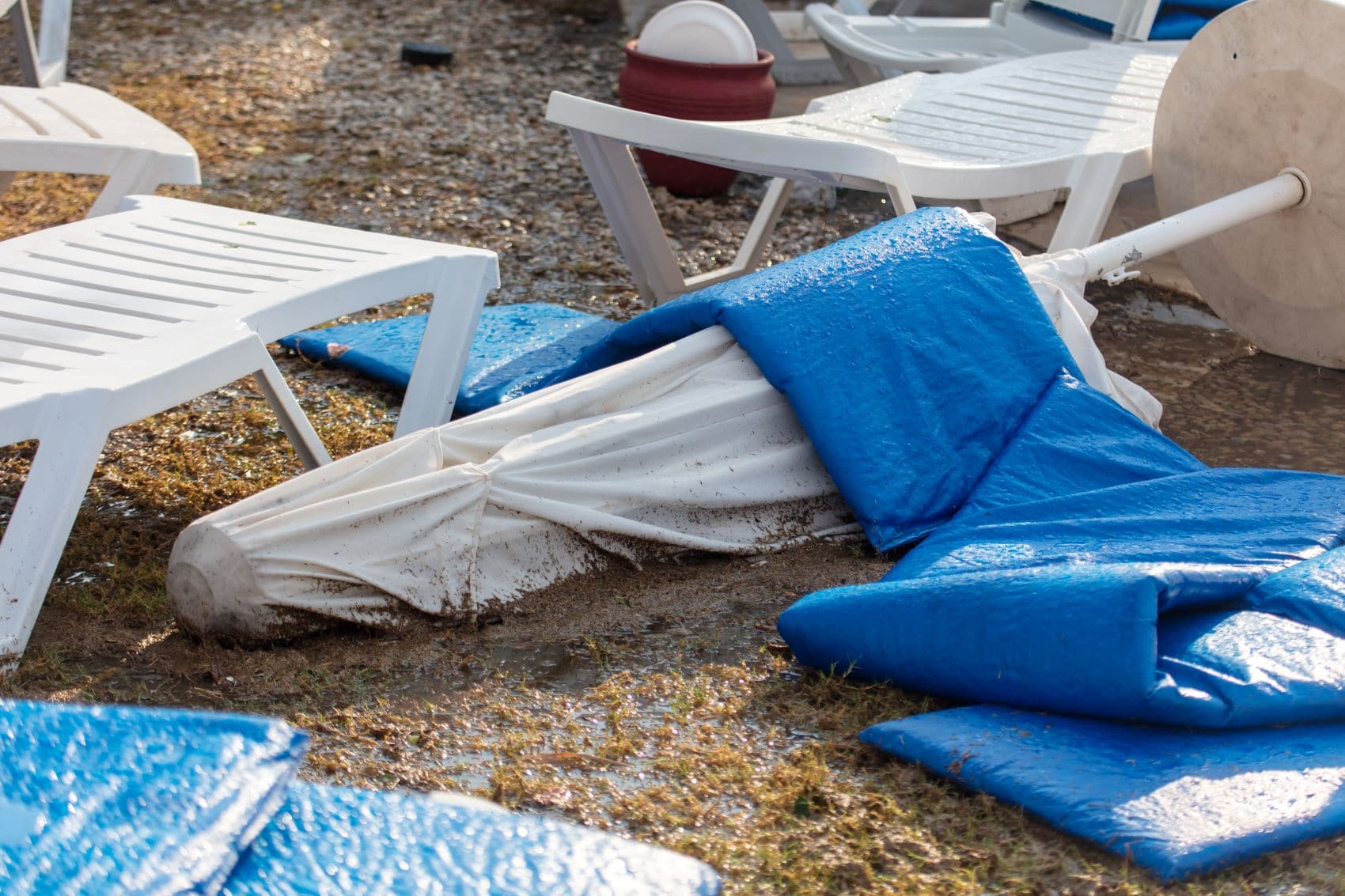 Umgefallener Sonnenschirm nach Regen am Strand