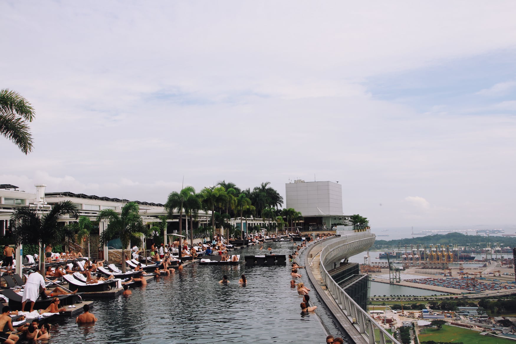 Menschen schwimmen im Infinity Pool auf dem Dach des Marina Bay Sands, eine der Sehenswürdigkeiten in Singapur 