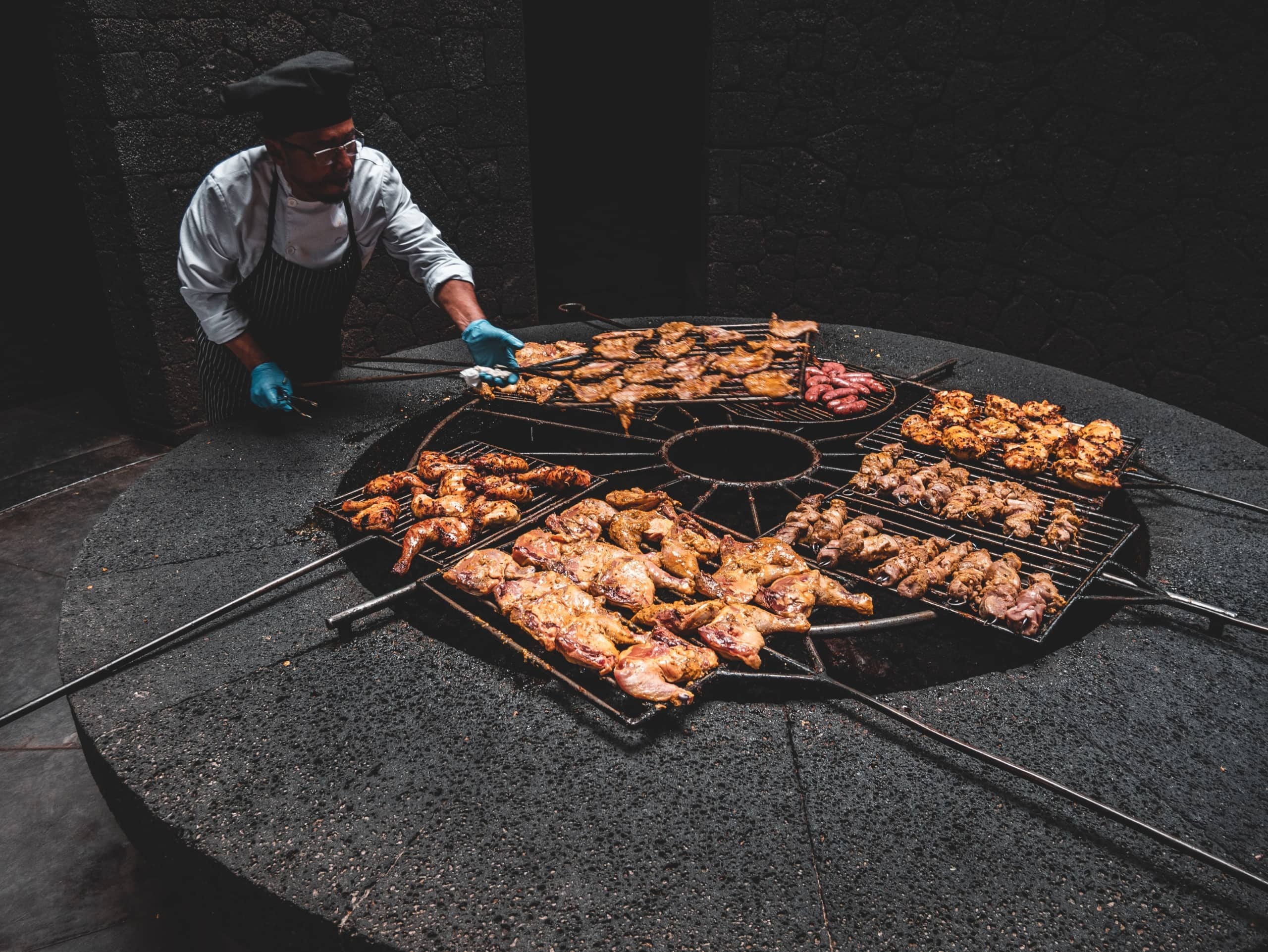 Mann brät Meeresfrüchte und Fleisch im Restaurant Timanfaya auf Lanzarote