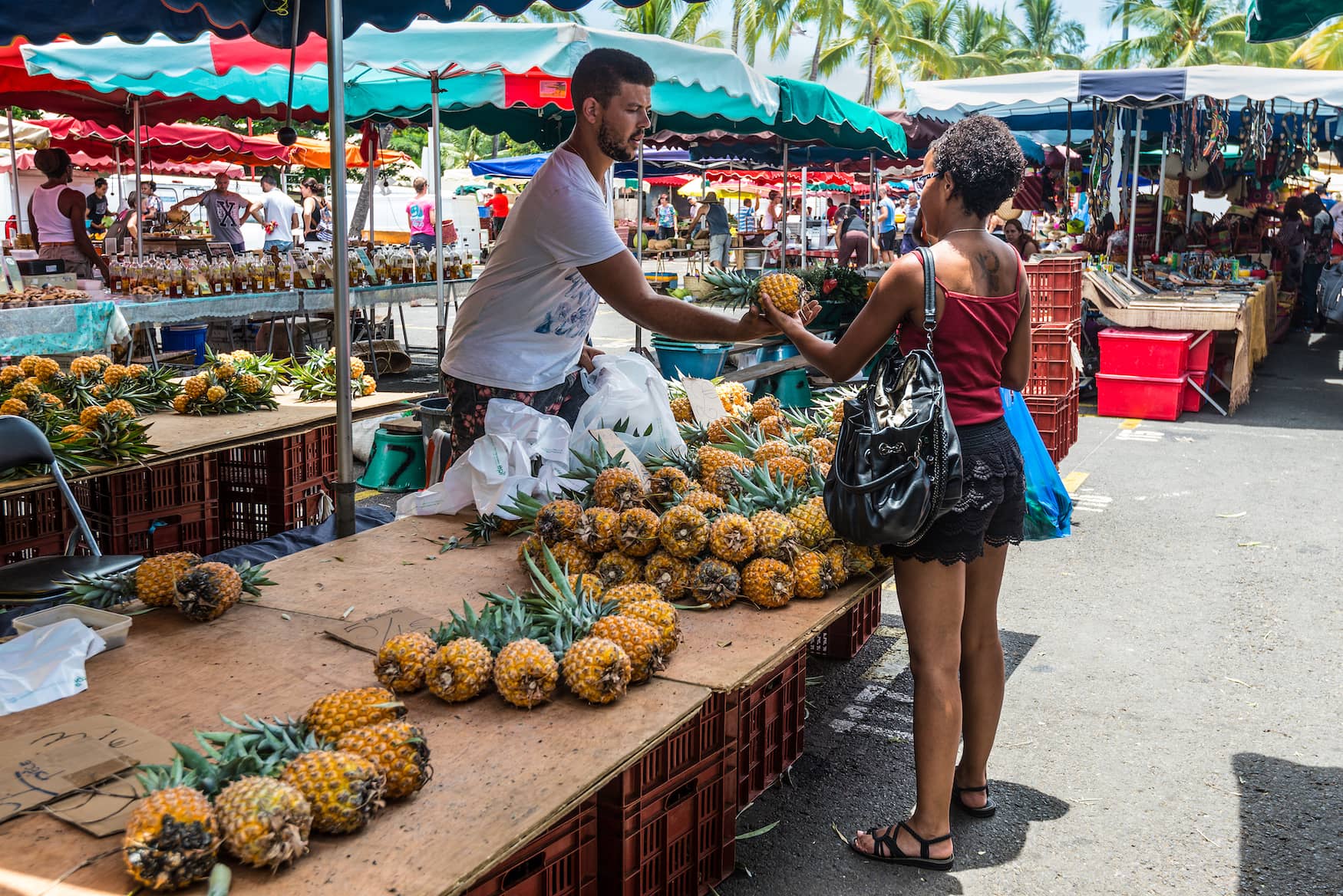 Frau kauft Ananas auf Markt in La Reunion, Frankreich