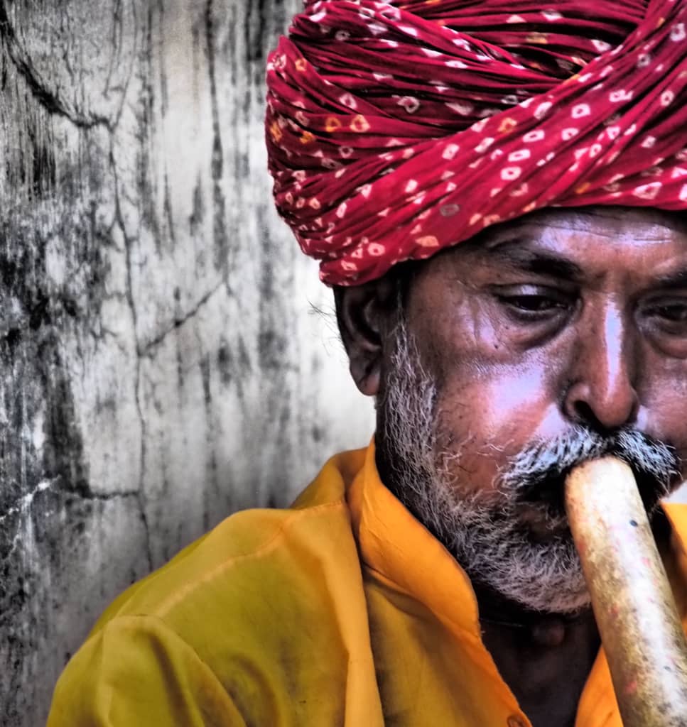 Mann mit Turban spielt Flöte in Rajasthan