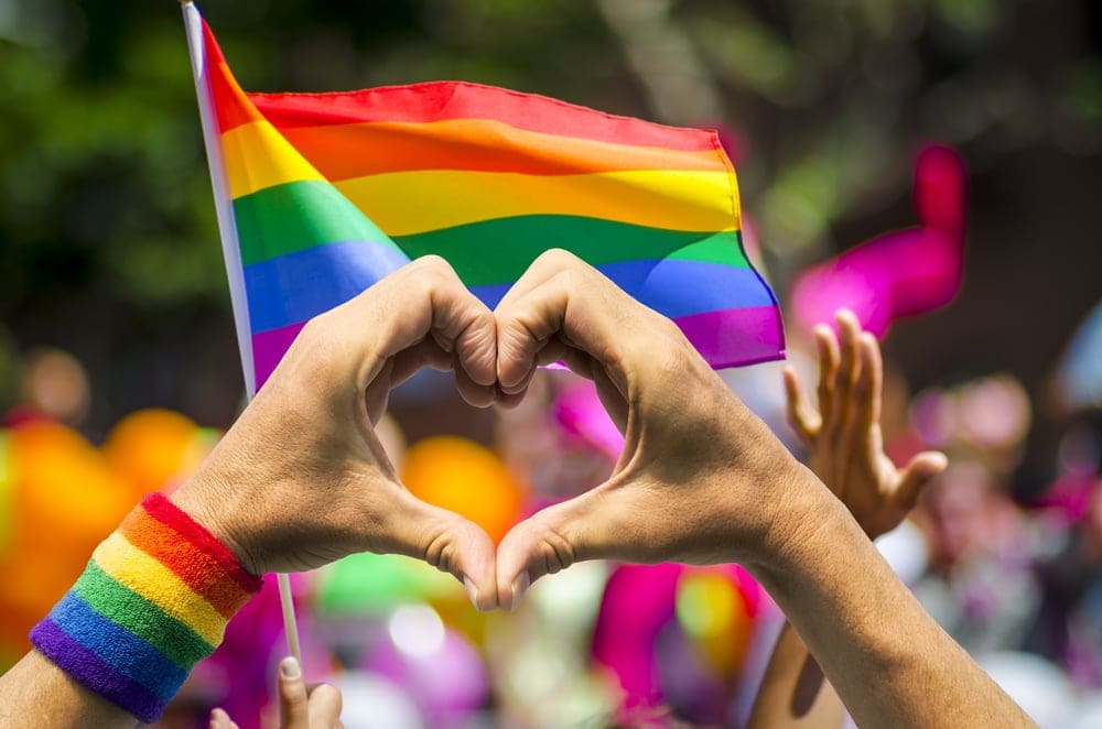 Regenbogenflaggen mit Herz- und Victory-Zeichen
