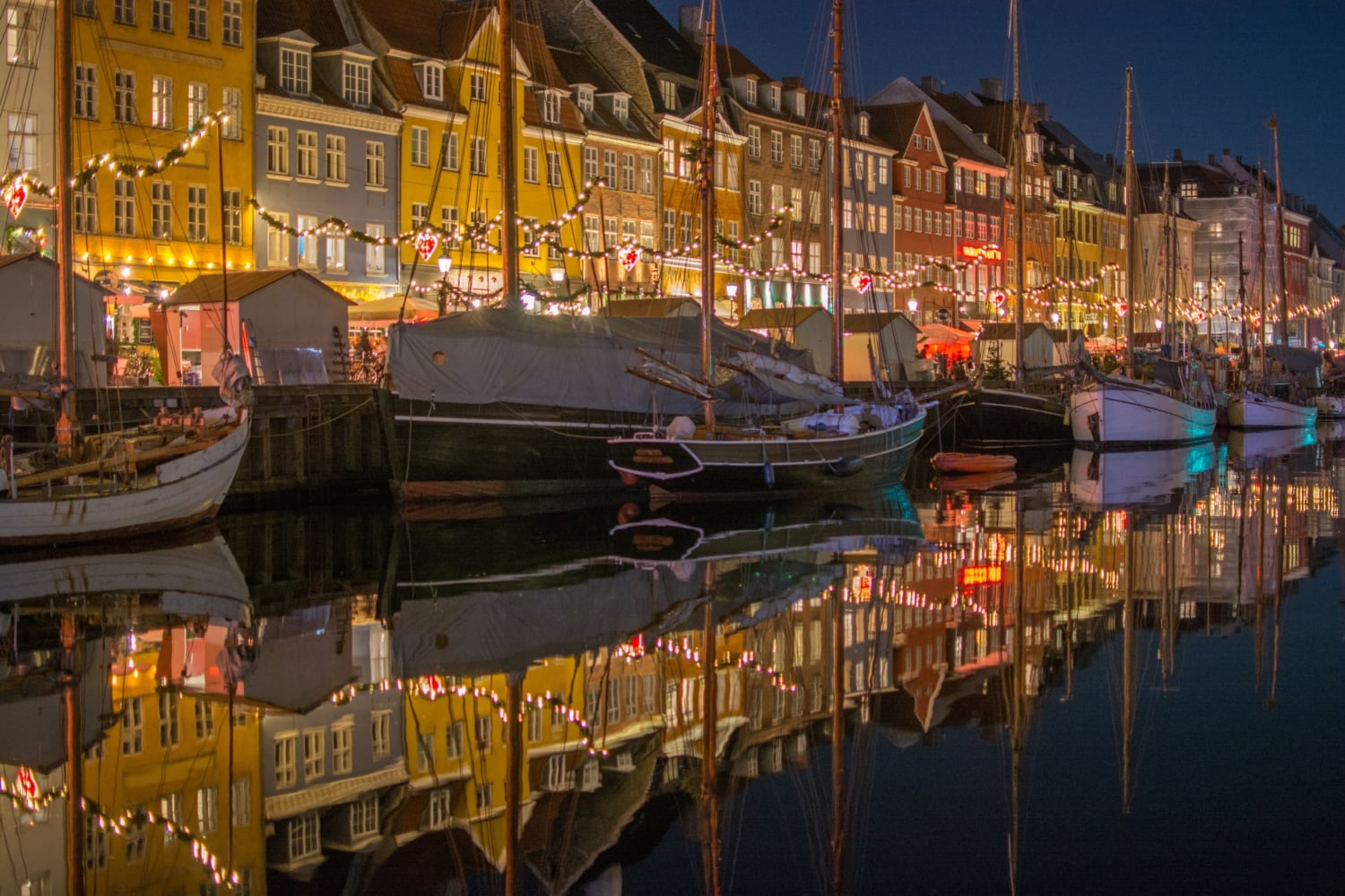 Hafen bei Nacht mit bunten Häusern die sich im Kanal reflektieren