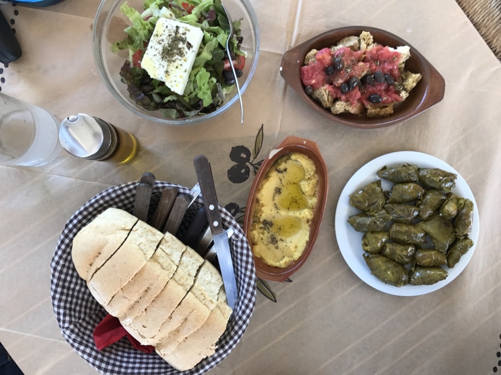 Meeze in Griechenland: Salat, Brot, Butter und Weinblätter auf gedecktem Tisch