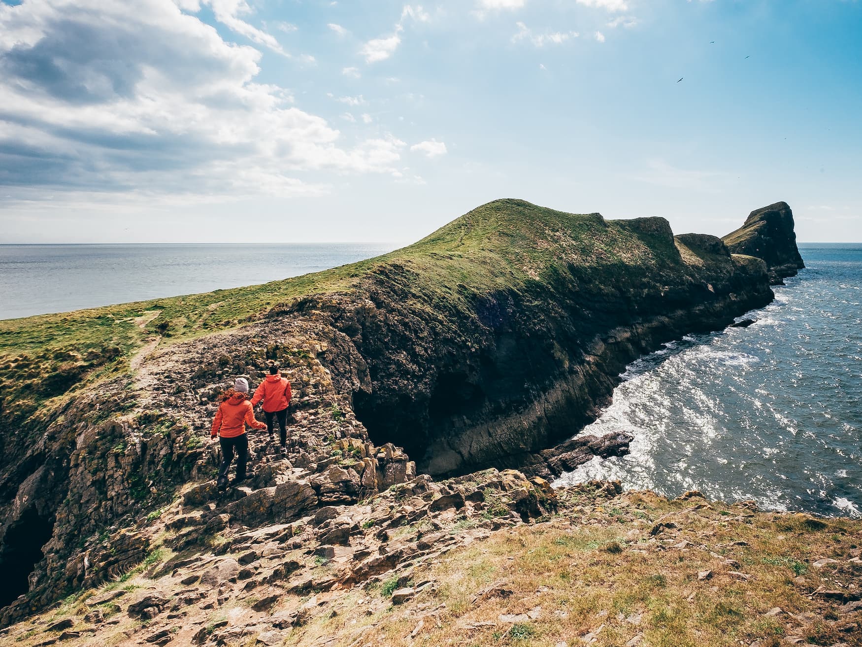 Zwei Frauen wandern entlang der Klippen auf dem Wales Coast Past in der Rhossili Bucht