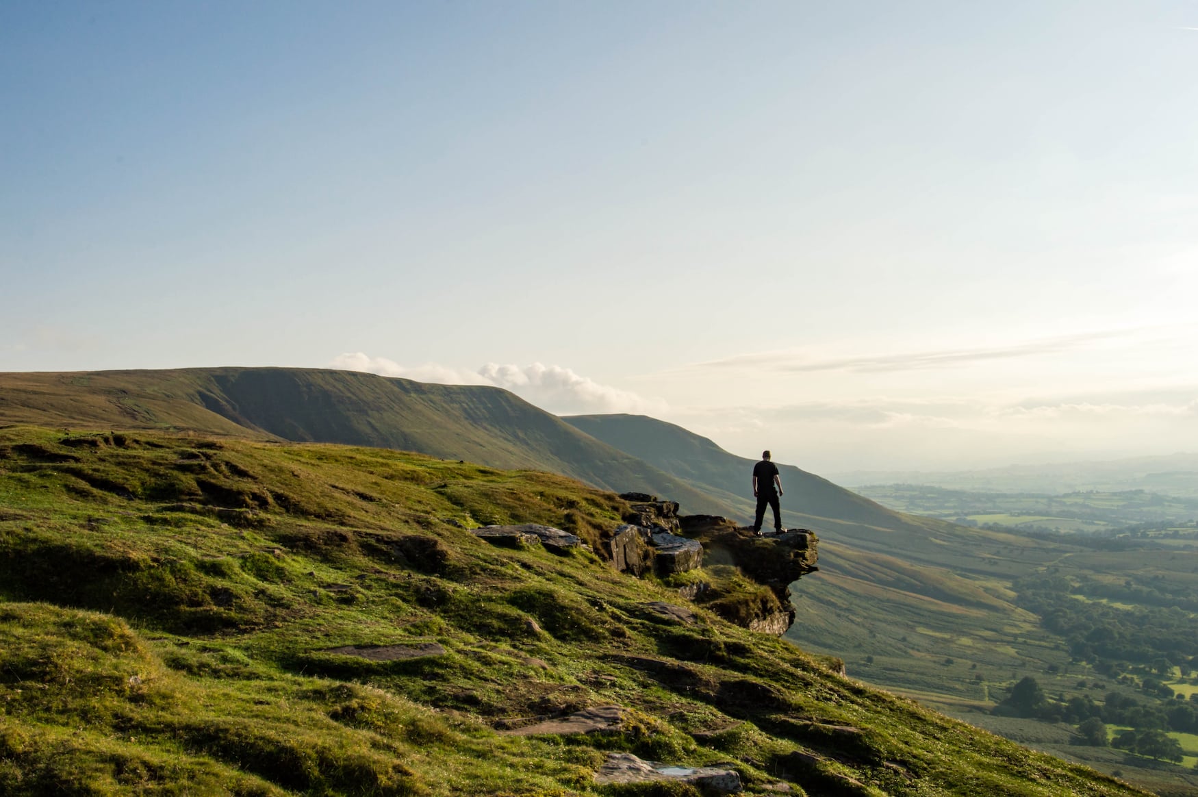 Mann steht an Klippe im Brecon Beacons Nationalpark