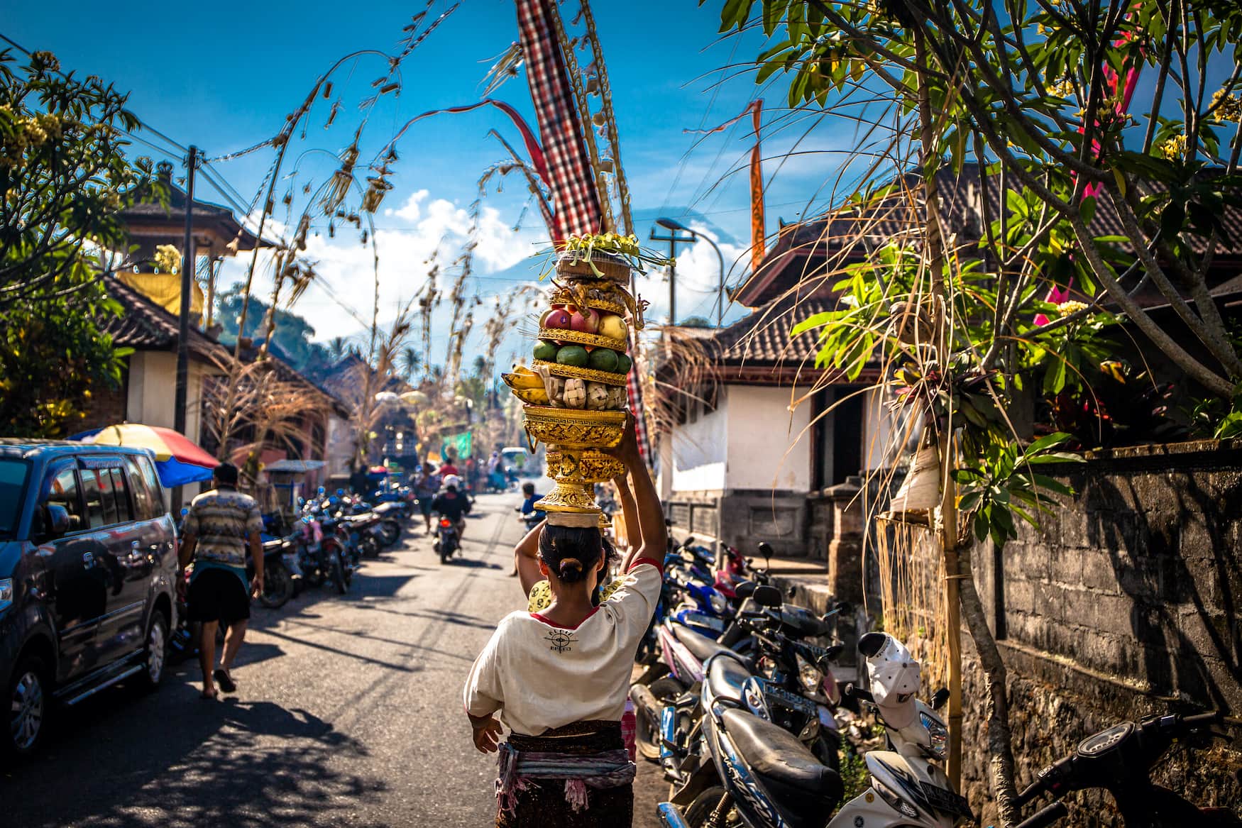 Frau trägt Lebensmittel auf dem Kopf in Dorf auf Bali