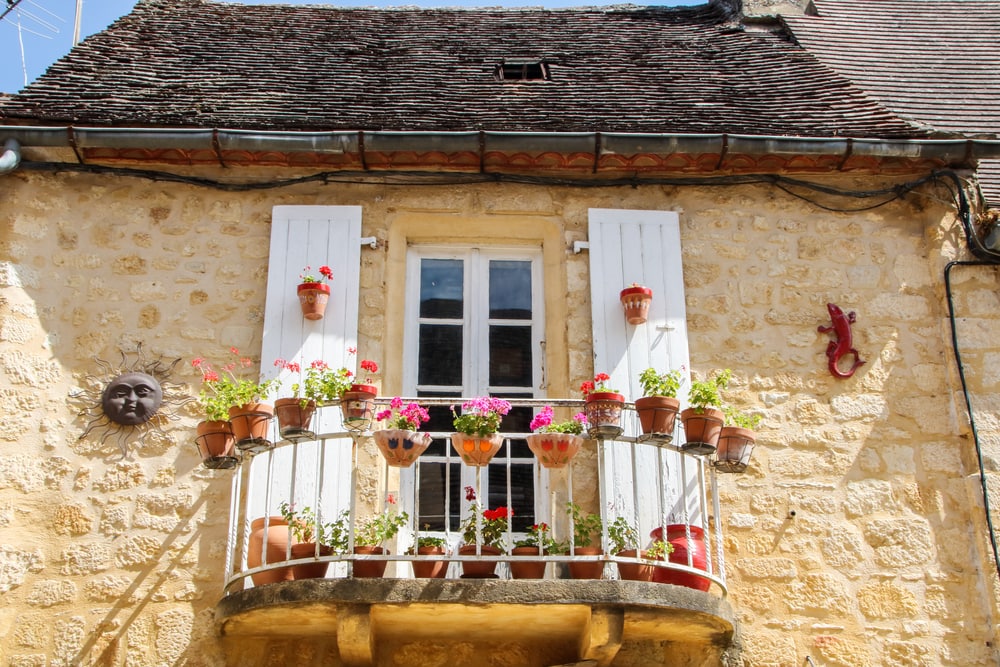 Französischer Balkon an Haus im Dorf Domme in Nouvelle-Aquitaine
