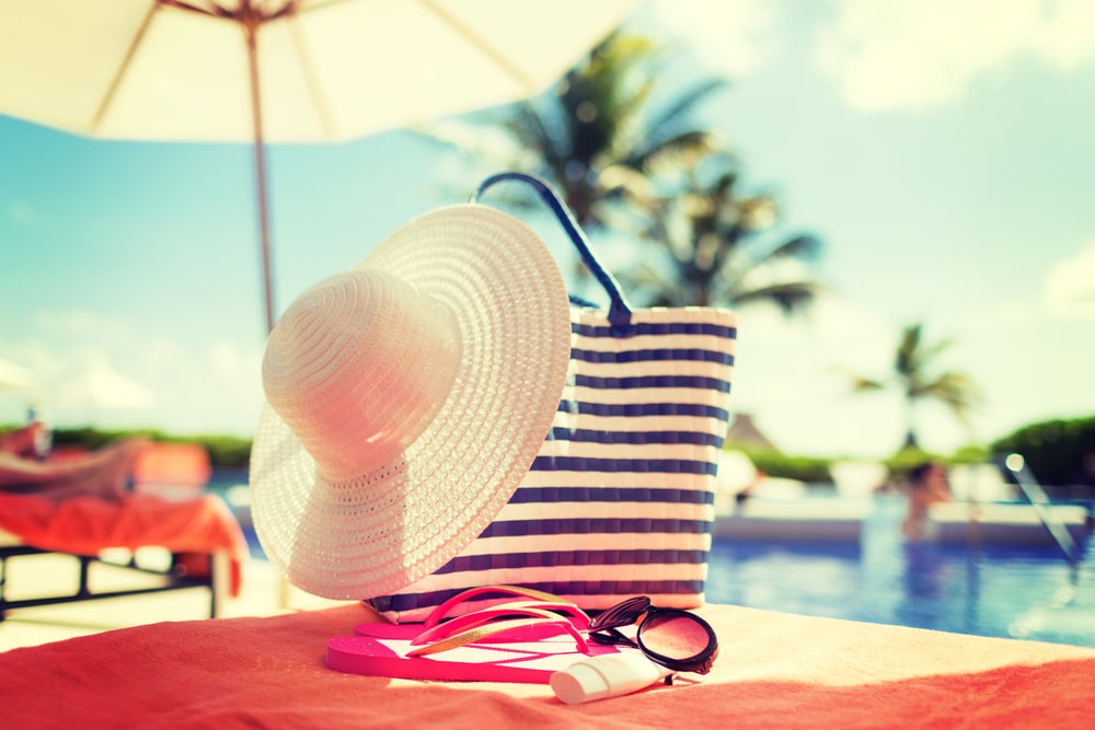 Hut und Handtuch auf Liege am Pool
