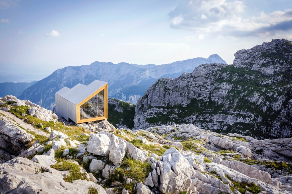 Links sieht man die dreizackige Alpine Shelter, dahinter machen sich die mächtigen Berge der Kamniker Alpen breit.