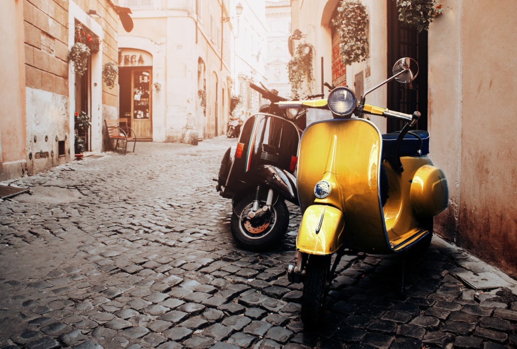 Gelbe Vespa steht in einer Seitenstraße in Rom