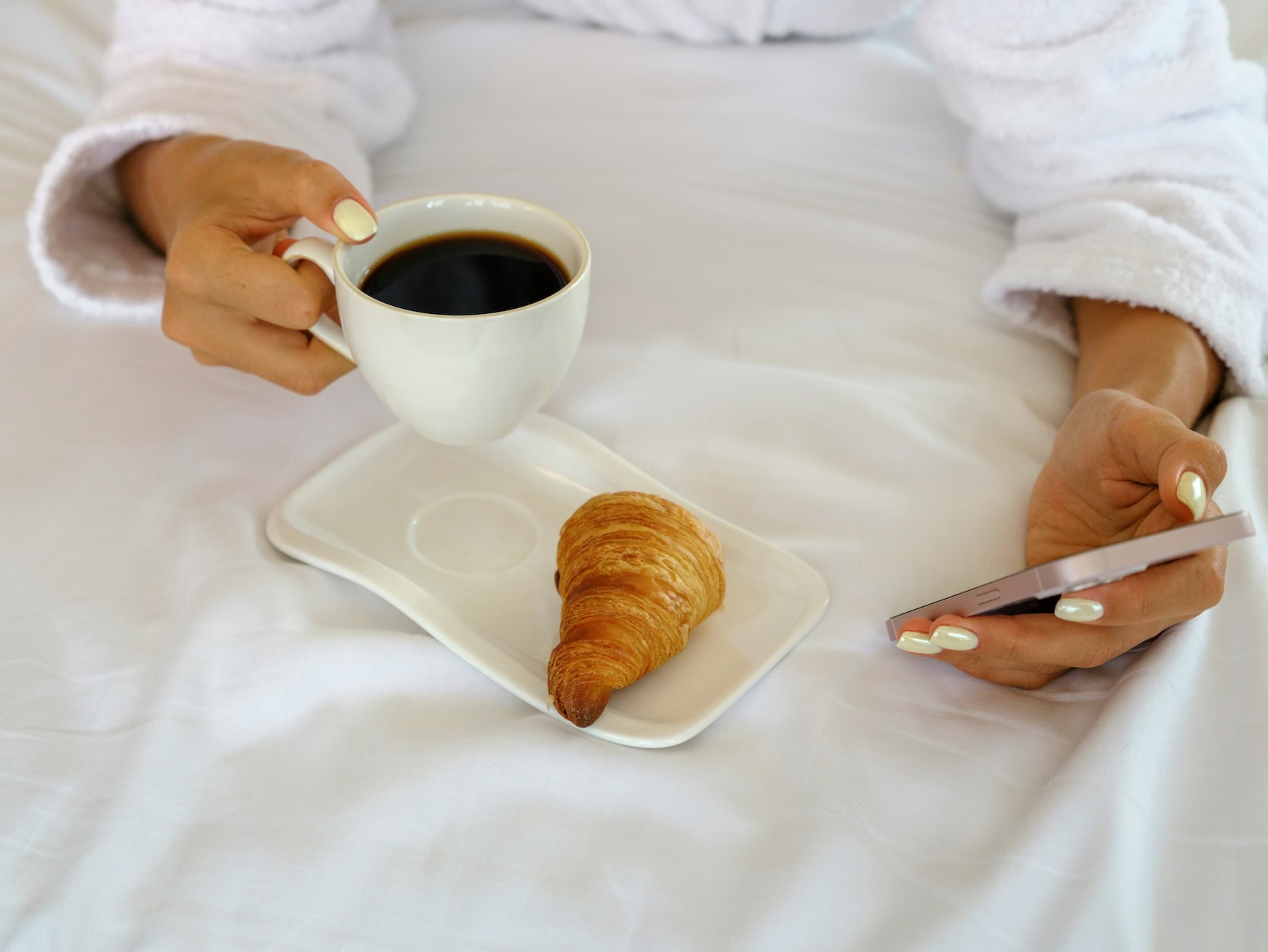 Smartphone im Bett mit Kaffee