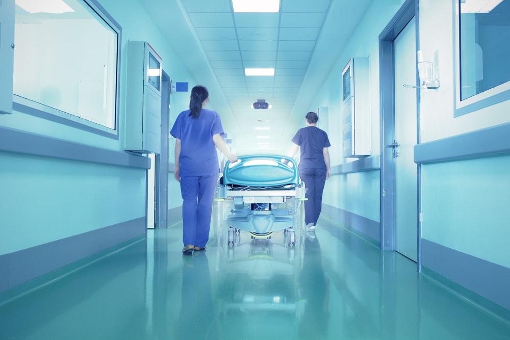 Zwei Krankenhauspfleger gehen einen Gang entlang