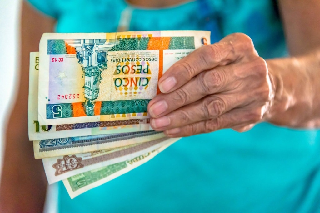Frau hält kubanische Pesos in der Hand